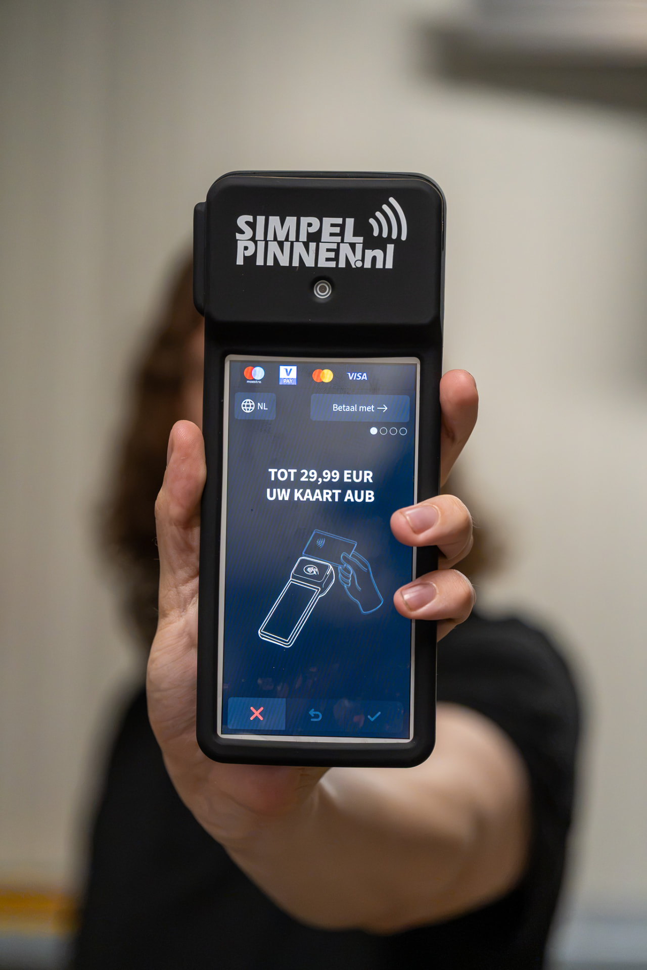Hand die een Simpel Pinnen pinautomaat vasthoudt
